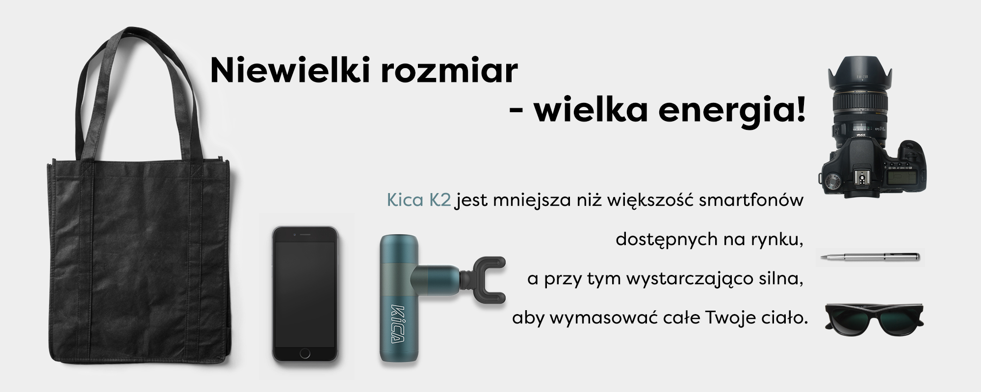 Grafika przedstawiająca masażer Kica K2 na tle smartfona, aparatu, długopisu i okularów przeciwsłonecznych. Jej rozmiar jest porównywalny do powyższych przedmiotów